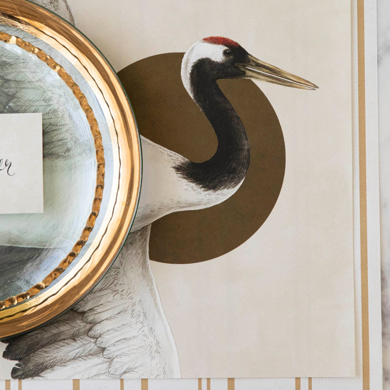 Eastern Crane Placemat peeking from underneath a stack of dinner plates.