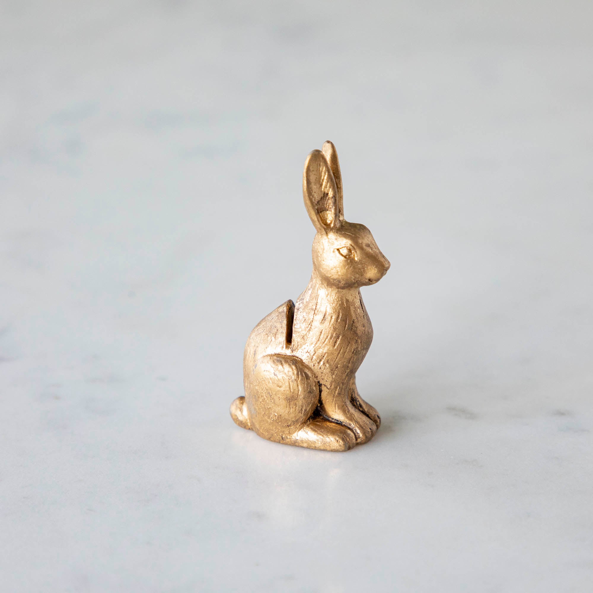 A side view of the Rabbit Name Card Holder showing its hind legs, slot in its back for a name card and lined details.