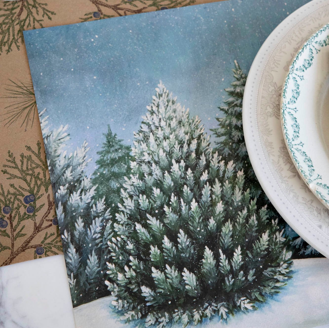 Evergreen Forest Placemat with white dinner plates and a Juniper Sprigs runner underneath. 