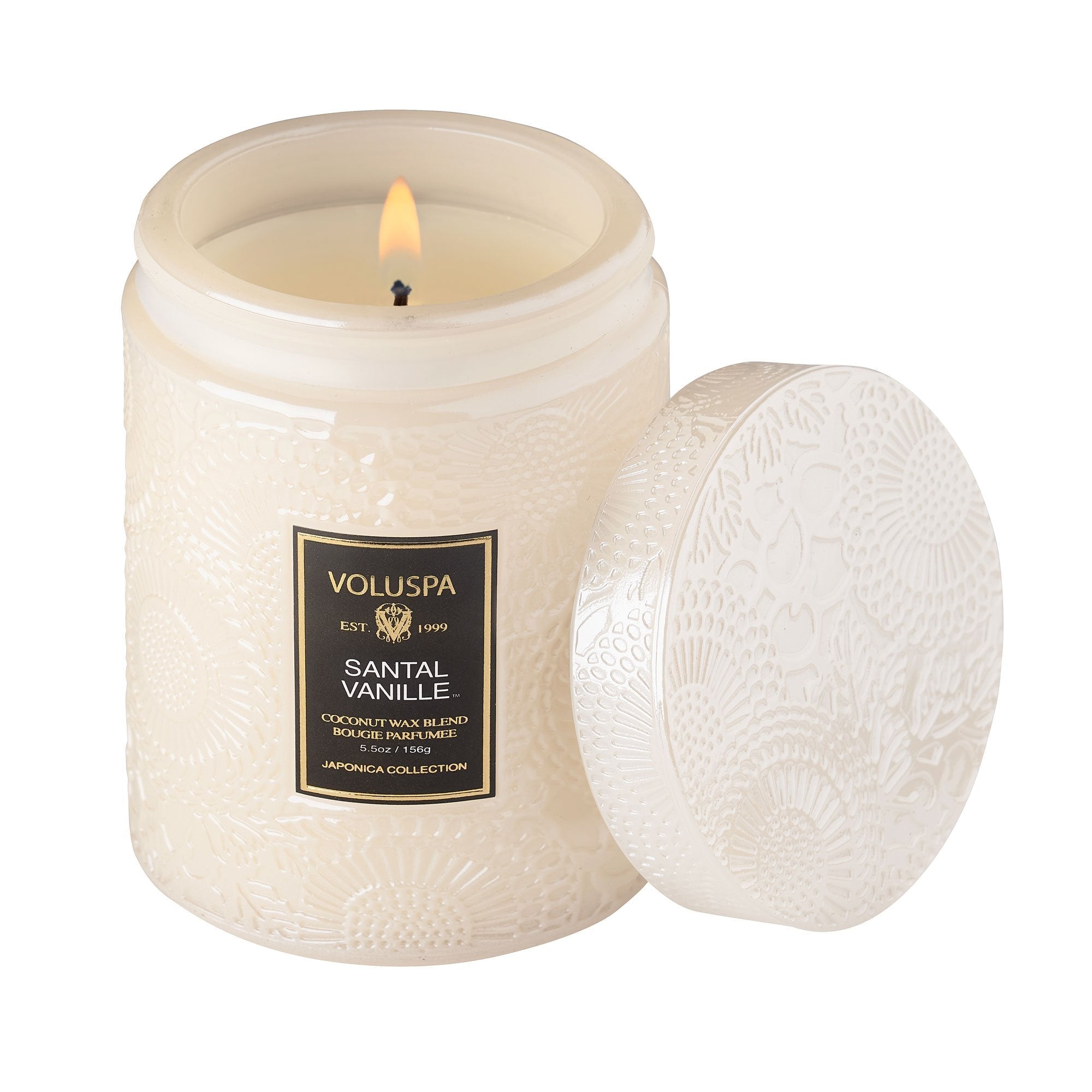White embossed glass candle burning