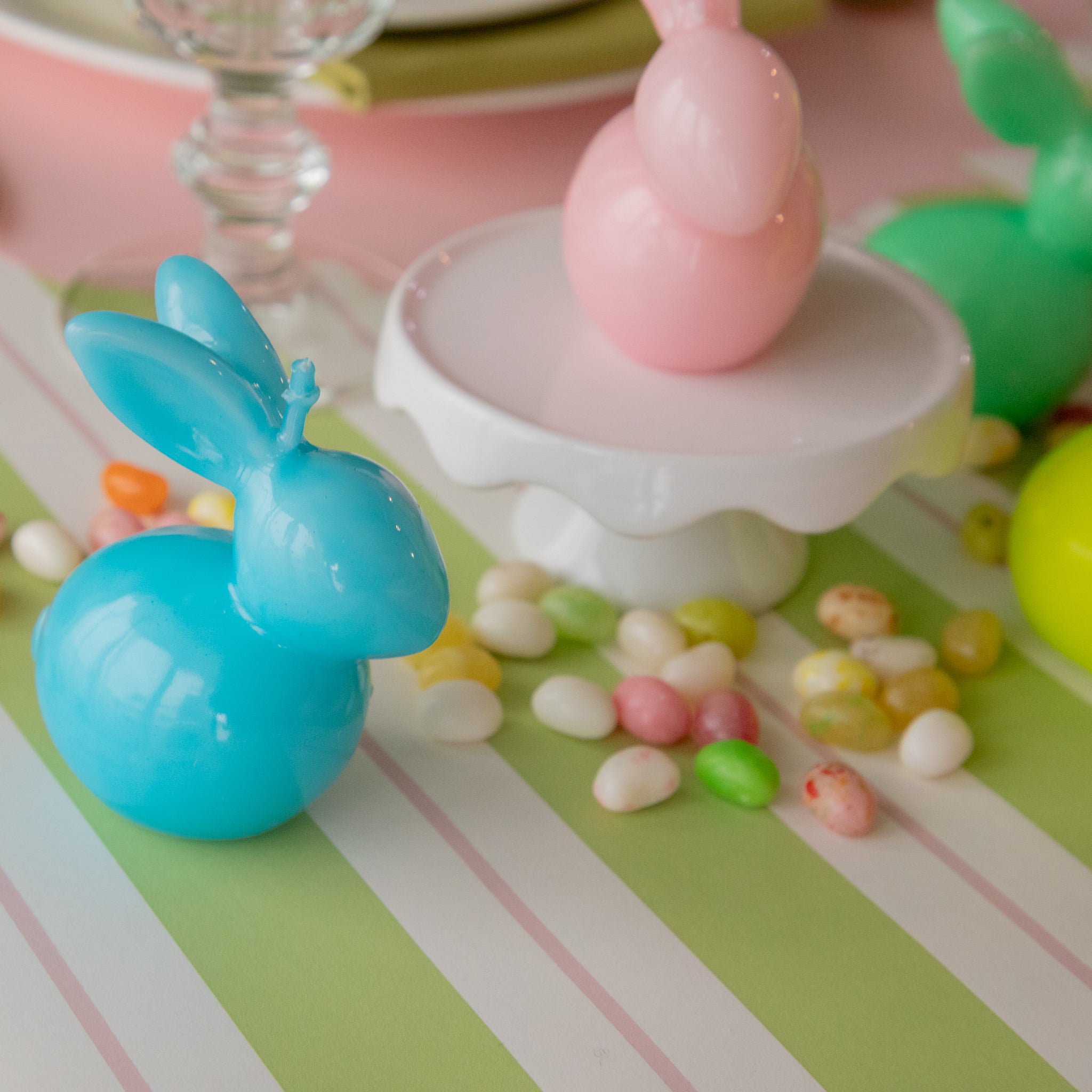 Bunny Candles in assorted colors styled in the center of two spring place settings.