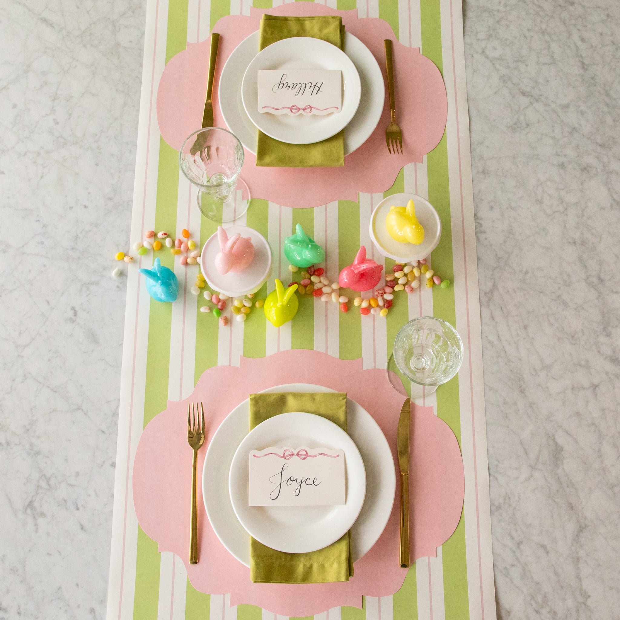 Bunny Candles in assorted colors styled in the center of two spring place settings.