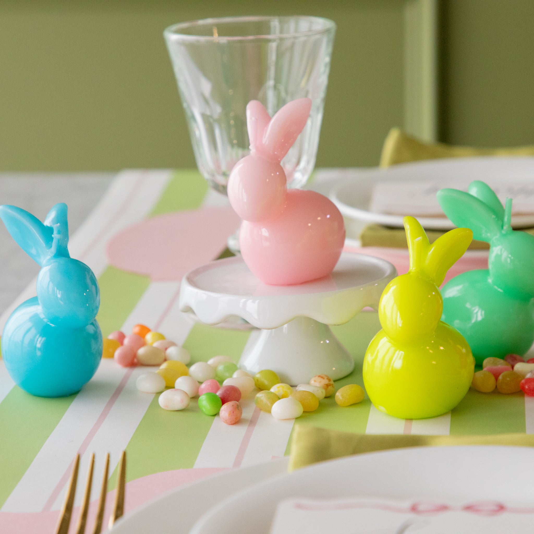 Bunny Candles in assorted colors styled in the center of two spring place settings.