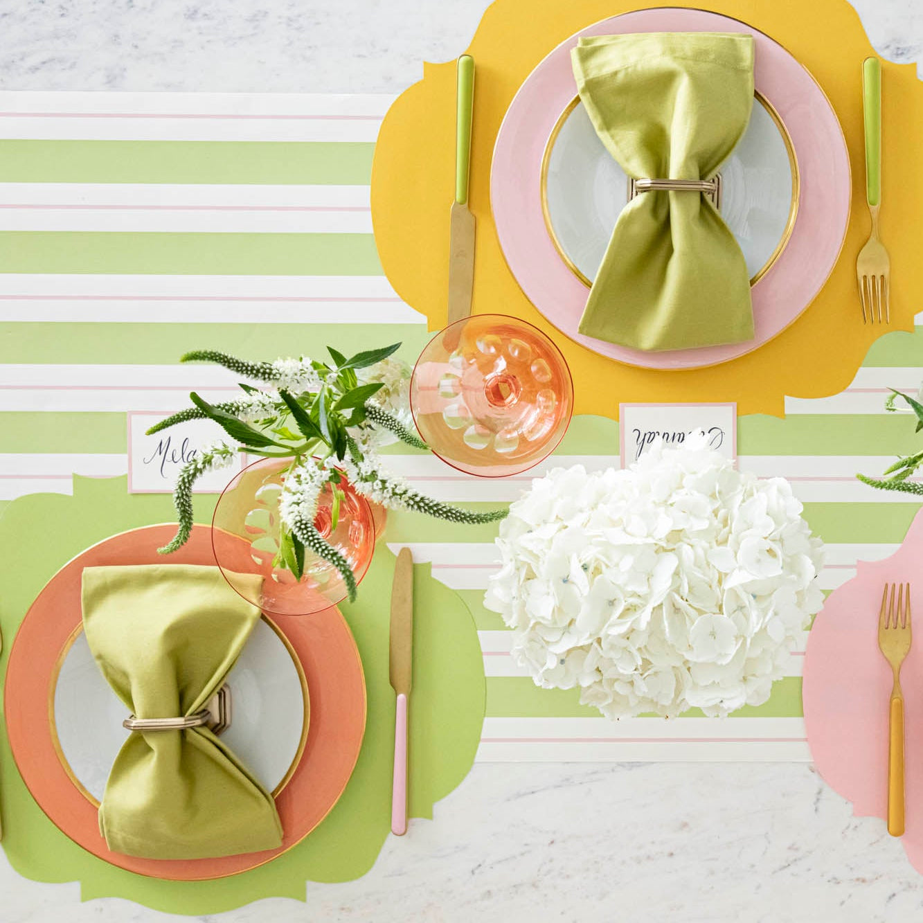 Die-cut Bright Green French Frame Placemat under a brightly colored place setting, on the Green &amp; Pink Awning Stripe Runner.