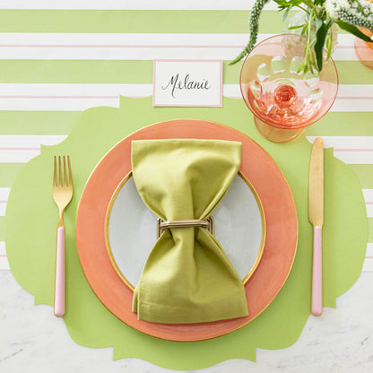 Die-cut Bright Green French Frame Placemat under a brightly colored place setting, on the Green &amp; Pink Awning Stripe Runner.