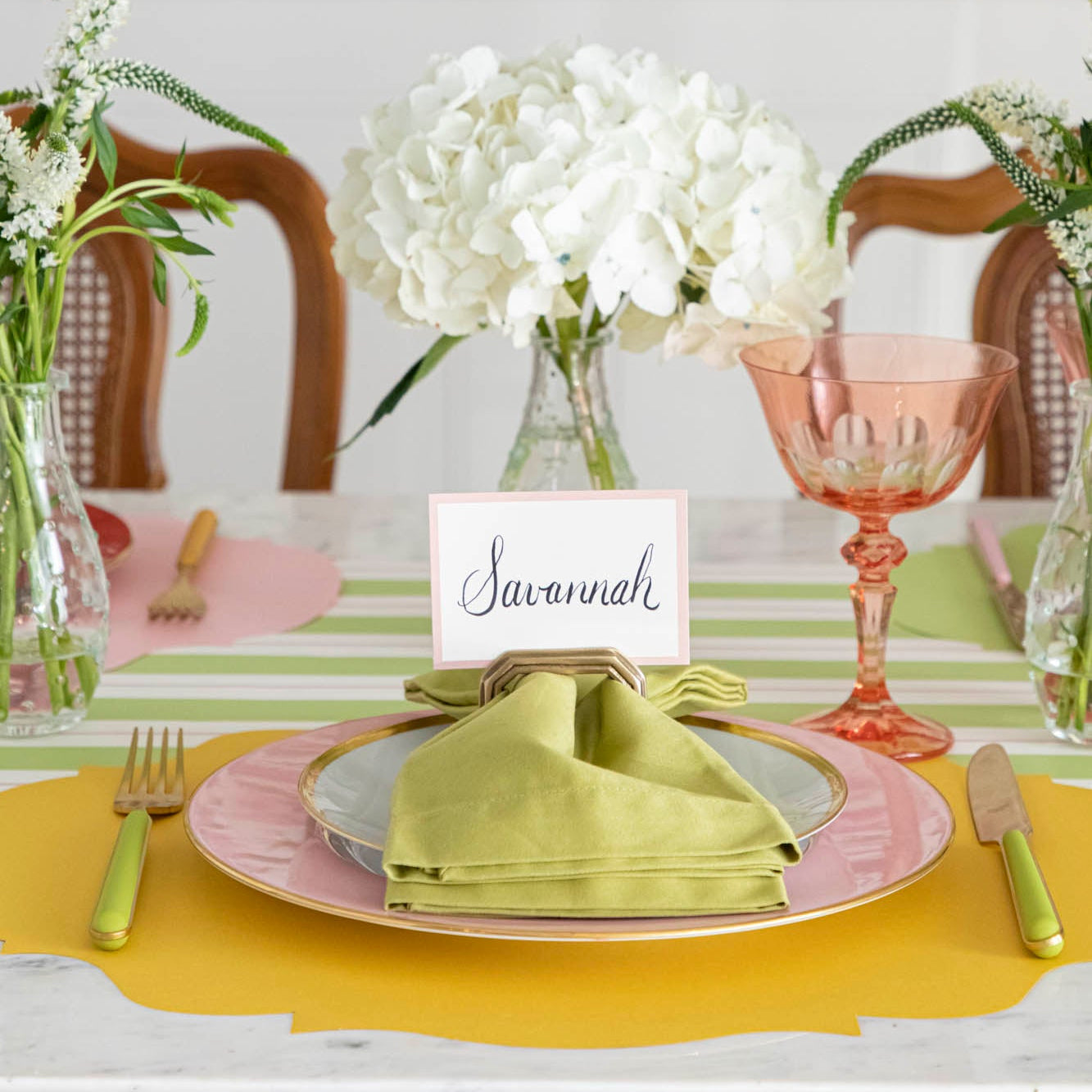 Die-cut Marigold French Frame Placemat under a place setting for one, on a spring themed table.