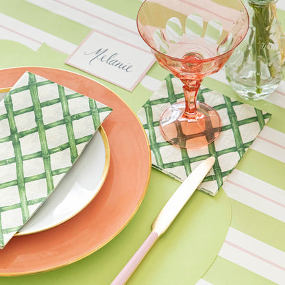 Die-cut Bright Green French Frame Placemat under a brightly colored place setting, on the Green &amp; Pink Awning Stripe Runner.