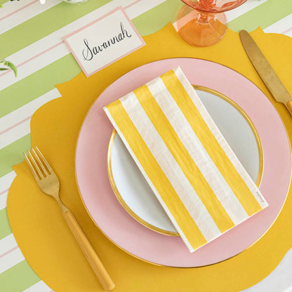 Die-cut Marigold French Frame Placemat under a place setting for one, on a spring themed table.