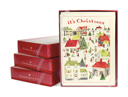 A red box with glittered Christmas Village Boxed Set Cards by Cavallini Papers &amp; Co. for Christmas greetings in it.