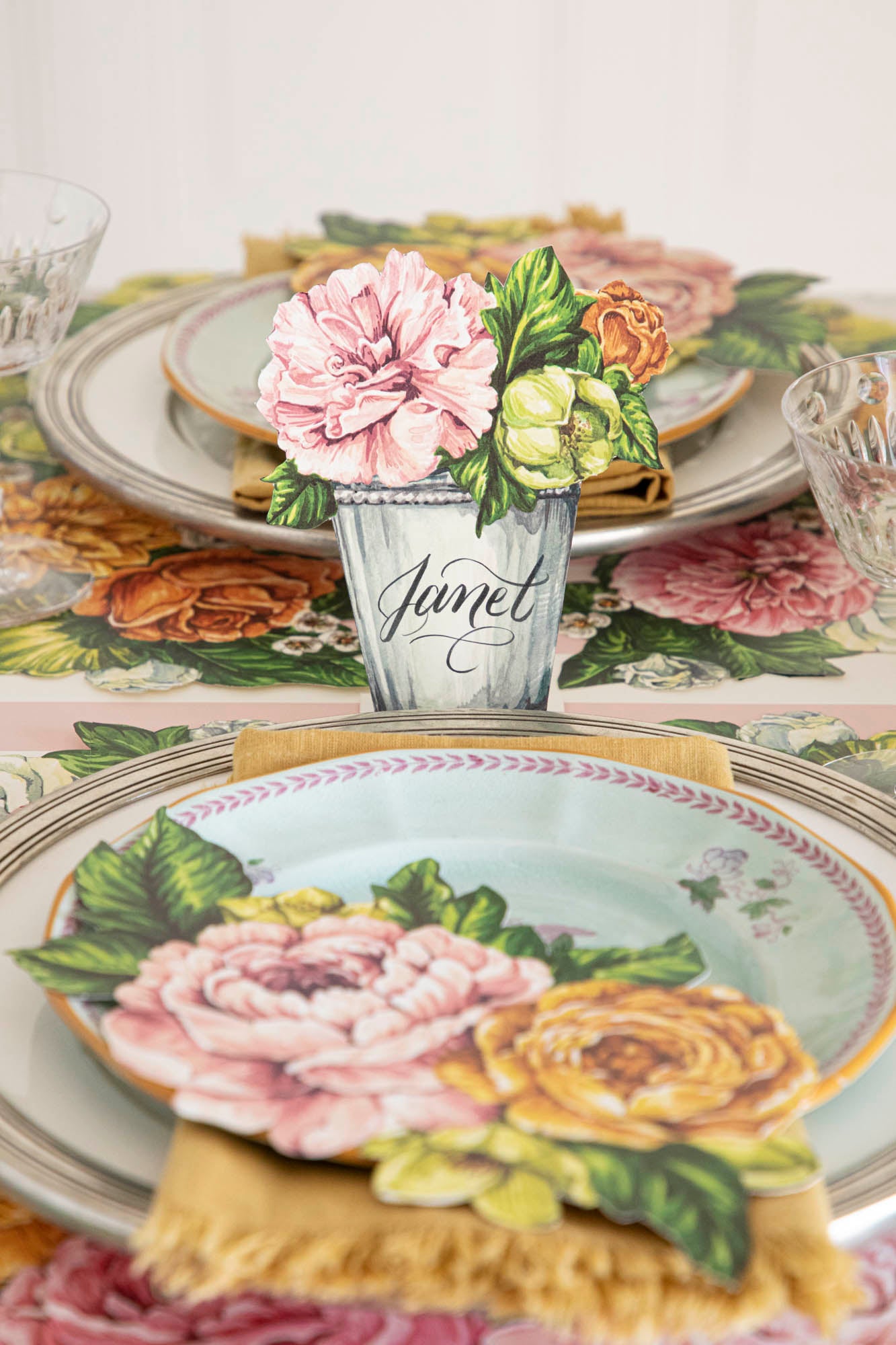 An elegant floral table setting featuring a Garden Derby Place Card labeled &quot;Janet&quot; standing behind the plate.