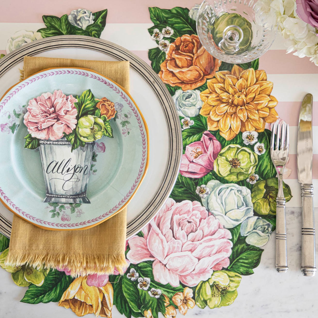 The Die-cut Derby Wreath Placemat under a bright floral place setting, from above.