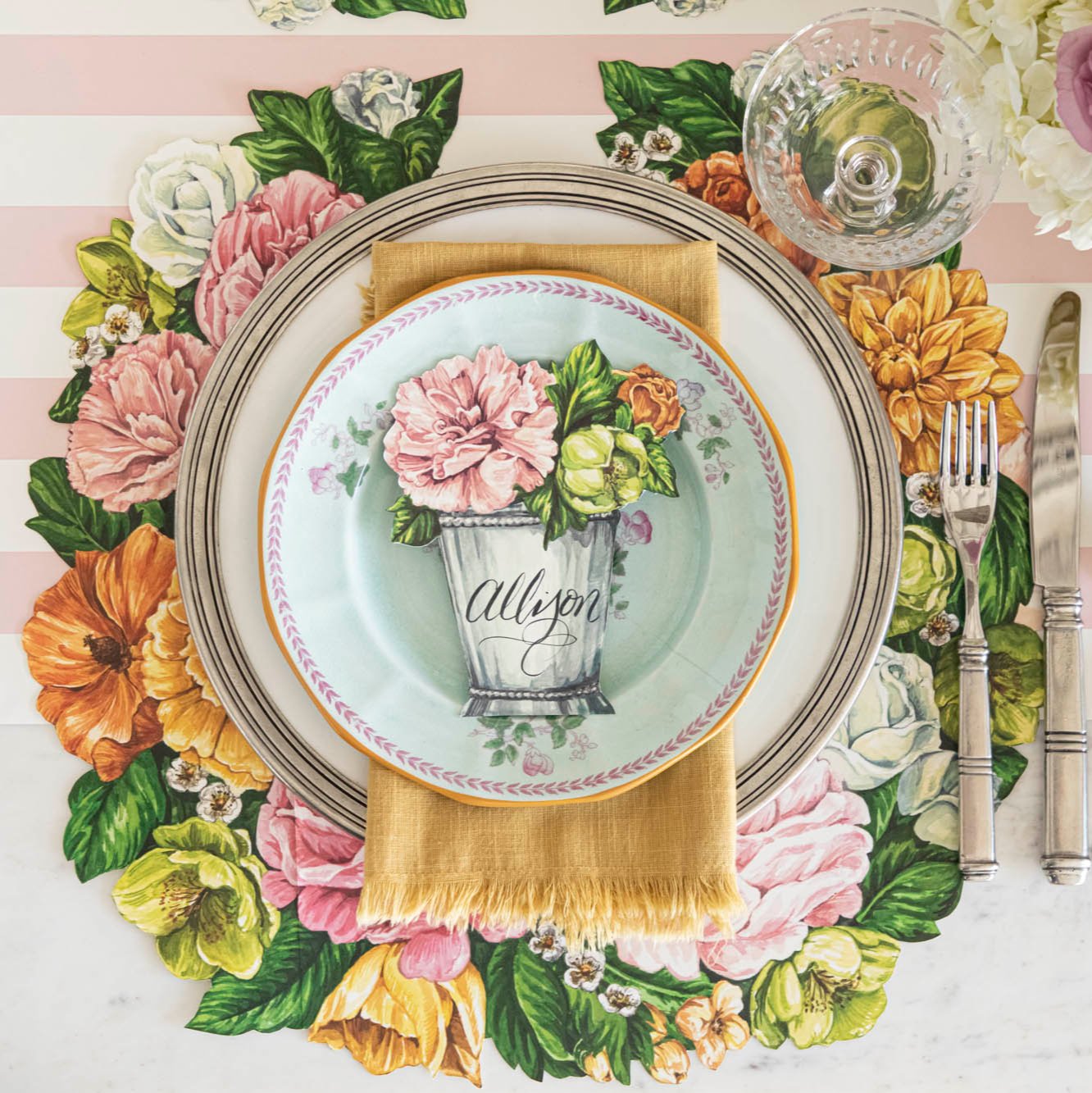 The Die-cut Derby Wreath Placemat under a bright floral place setting, from above.