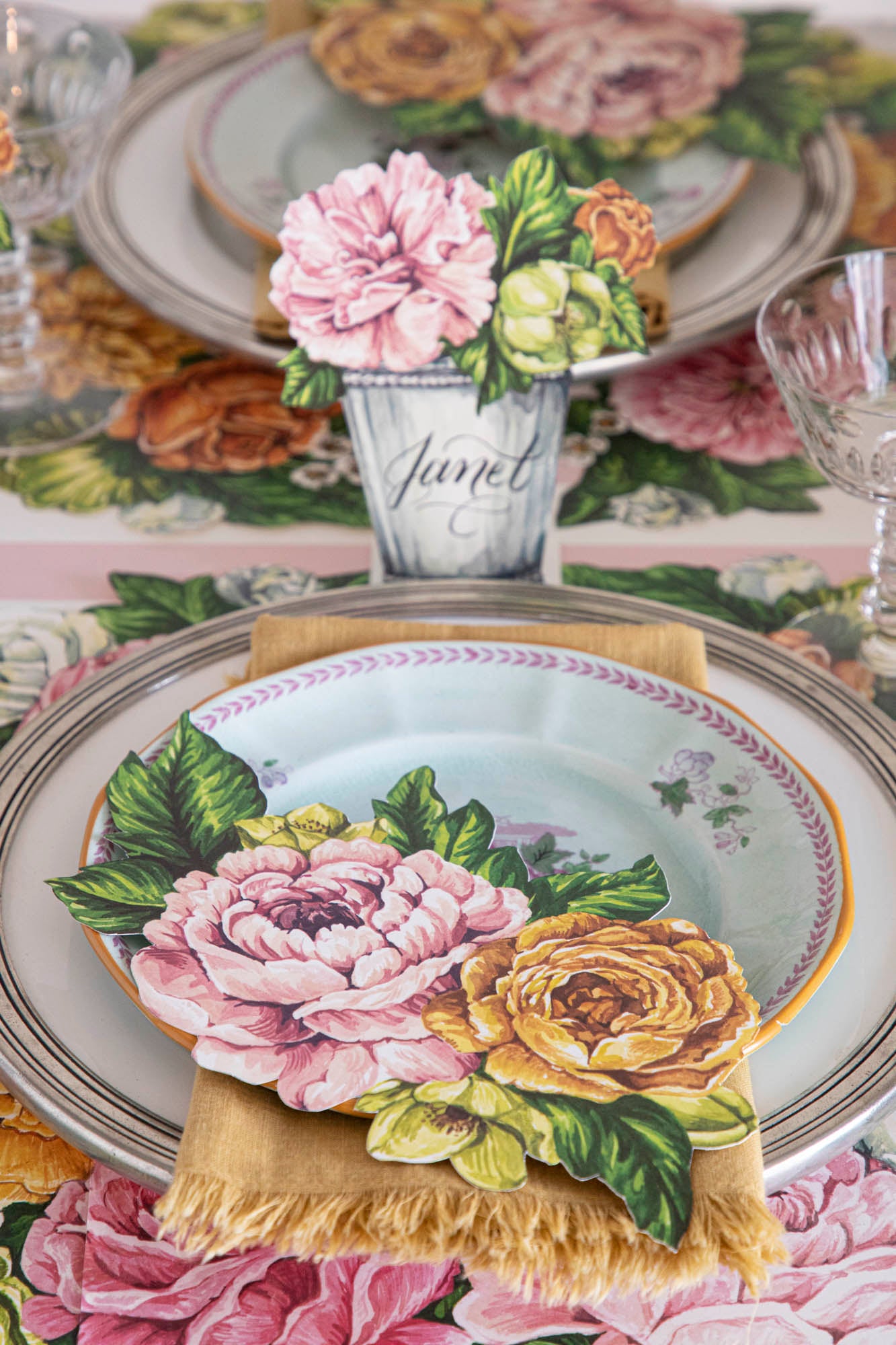 An elegant floral table setting featuring a Garden Derby Place Card labeled &quot;Janet&quot; standing behind the plate.