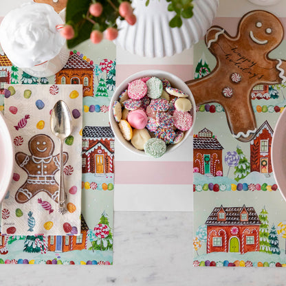 Pink Classic Stripe Runner under the Gingerbread Village Placemat with a place setting for two.