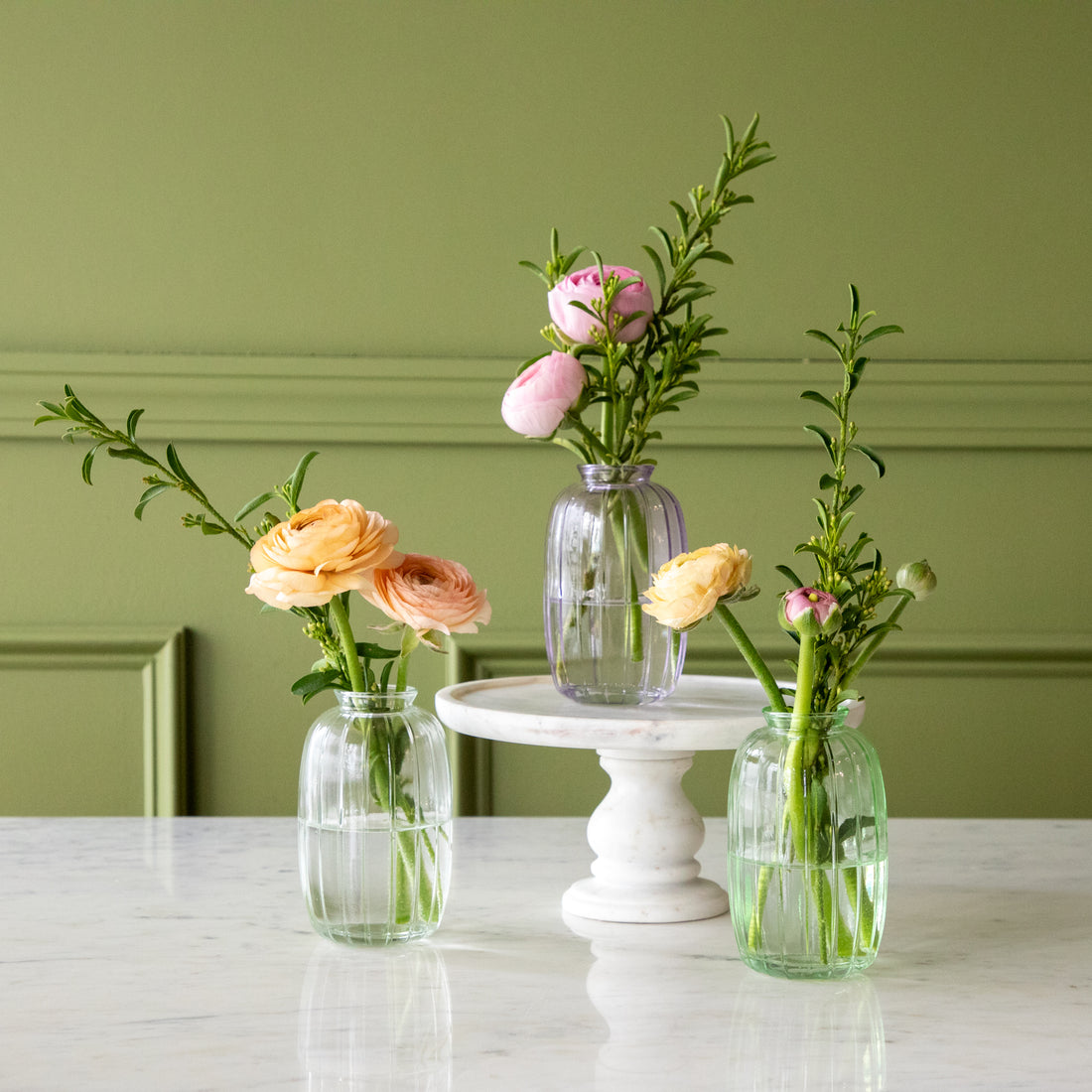 Lilac, green and clear Glass Bud Vases with spring flowers in them.