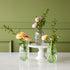 Lilac, green and clear Glass Bud Vases with spring flowers in them.