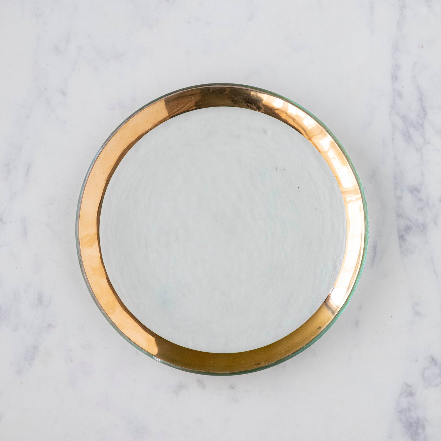 Annie Glass Roman Antique Salad Plate, adorned with a 24-karat gold band, on a marble table.