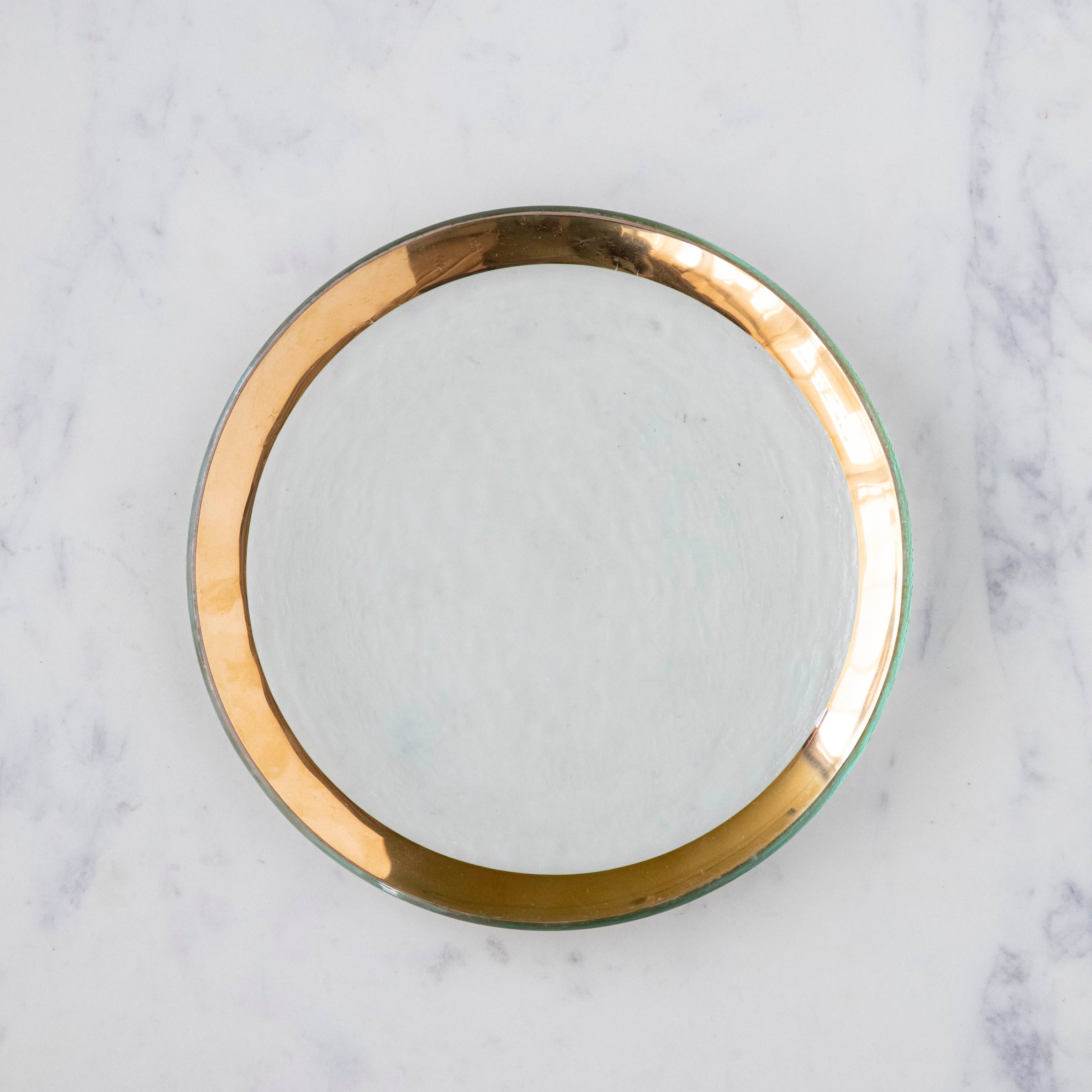 Annie Glass Roman Antique Salad Plate, adorned with a 24-karat gold band, on a marble table.