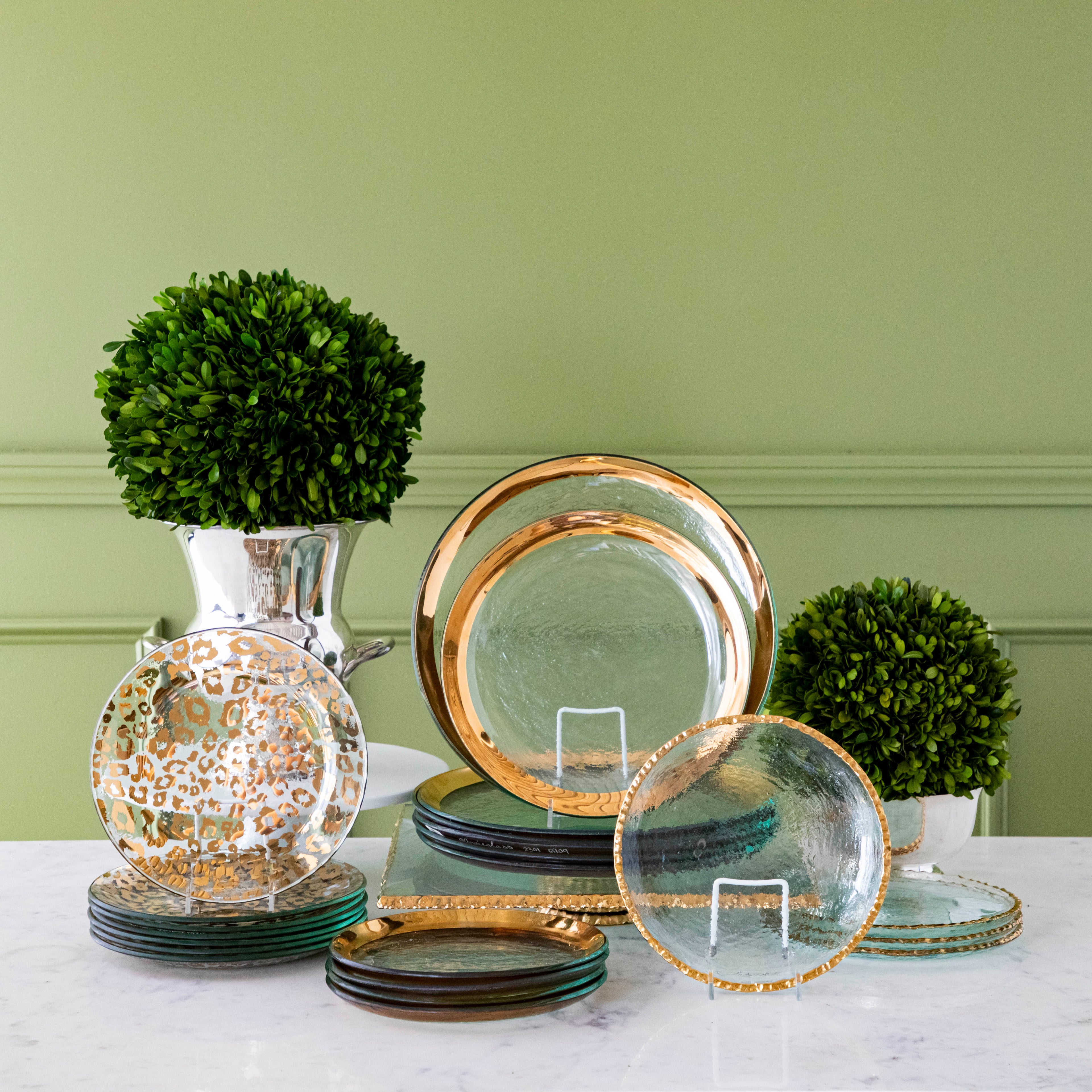 Annie Glass Roman Antique Dinnerware, Edgy Salad Plates, and Cheetah Print Plates all stacked up and displayed with Boxwood Topiary on a marble table.