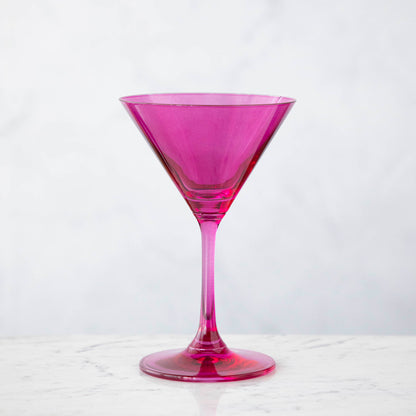 A pink crystal stemware wine glass on a marble table.