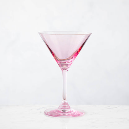 A pink crystal stemware wine glass on a marble table.