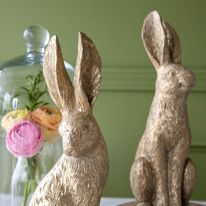 Gold Leaf Rabbits in front of a jar of flowers.