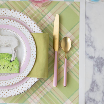 Bright Green Plaid Placemat under a place setting with gold and pink dinnerware.