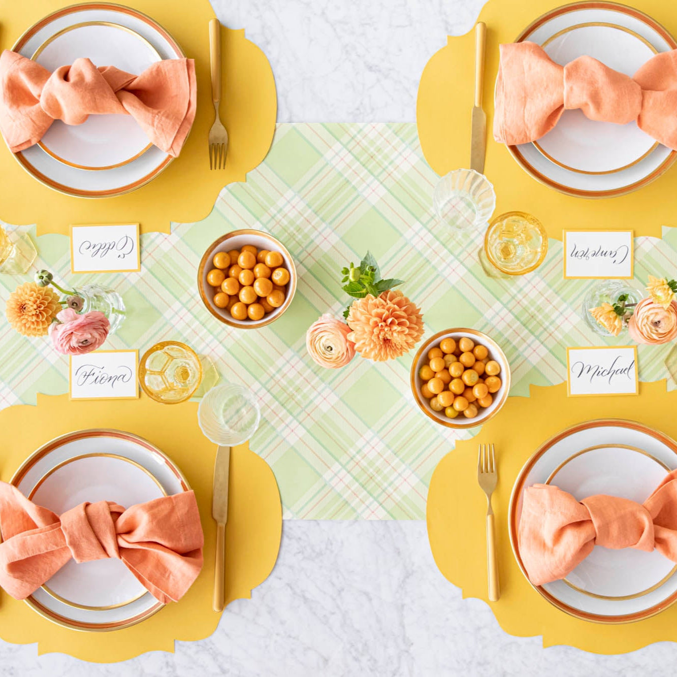 A colorful table setting for four with the Bright Green Plaid Runner under the Die-cut Marigold French Frame Placemat and place setting.