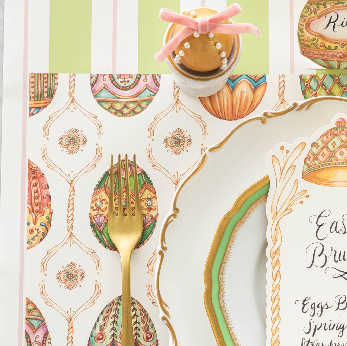 A close up of the Exquisite Egg Hung Placemat with a gold fork on top.