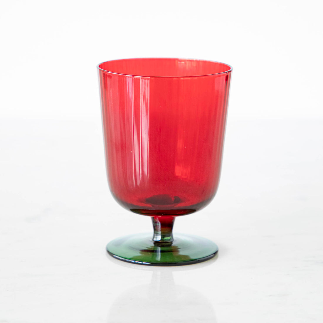 Green &amp; red stemmed flute glass on a white background.