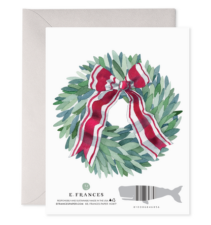 Back of card with illustration of green wreath with a red &amp; white ribbon tied in it. 