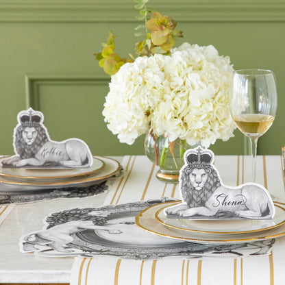 Regal Lion Place Cards propped upwards on dinner plates, on an elegantly styled table setting for two.