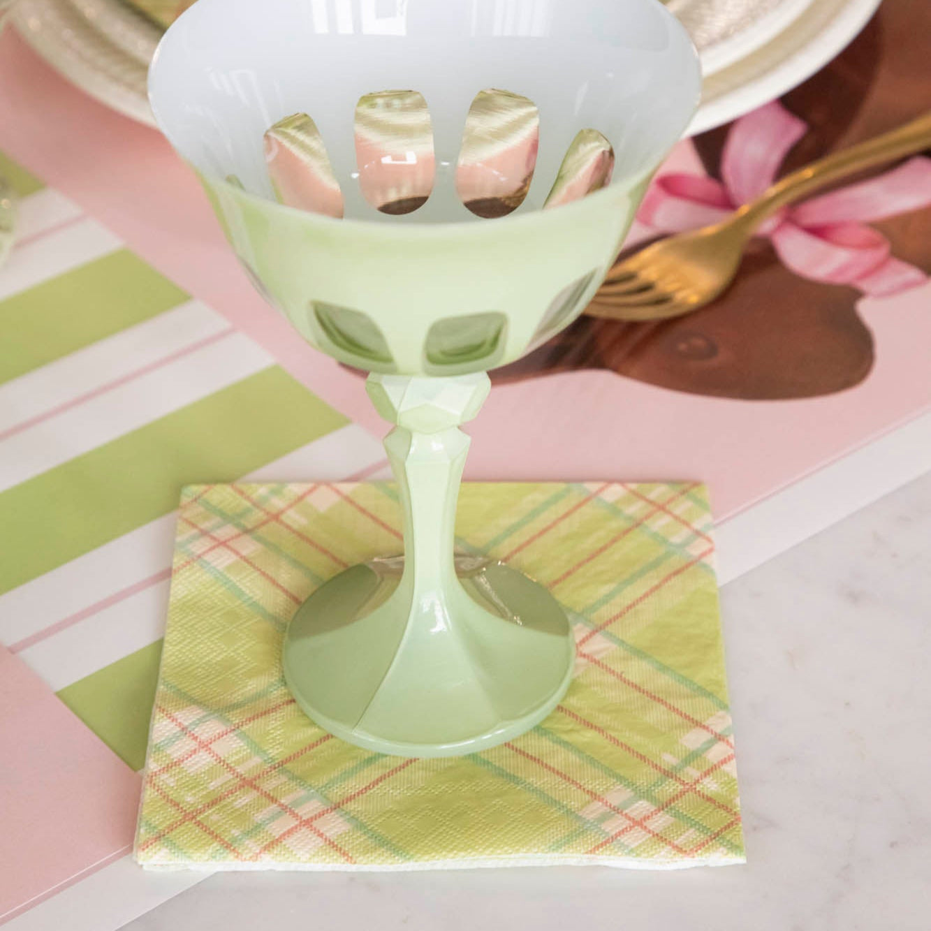 Bright Green Plaid Cocktail Napkin under an empty glass, next to a place setting for one.