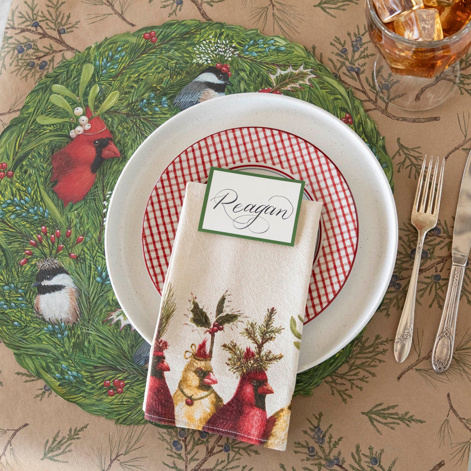 A nature themed table setting featuring the Holiday Party Cardinal Napkin resting on dinner plates.