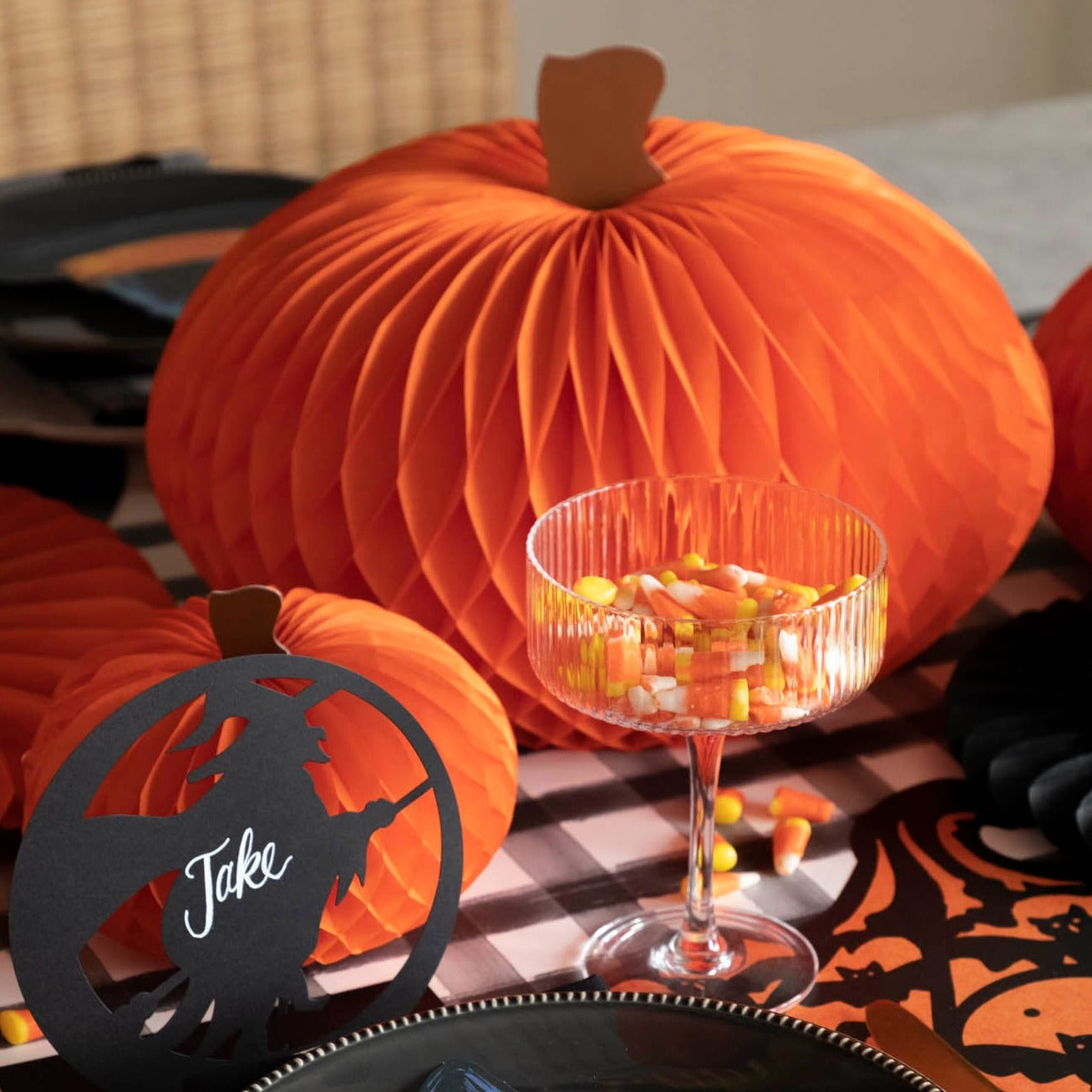 Orange honeycomb pumpkins on a Halloween themed table.