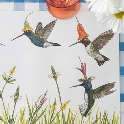 Close-up of the Hummingbirds Placemat under a place setting, showing hummingbirds with flower hats in detail.