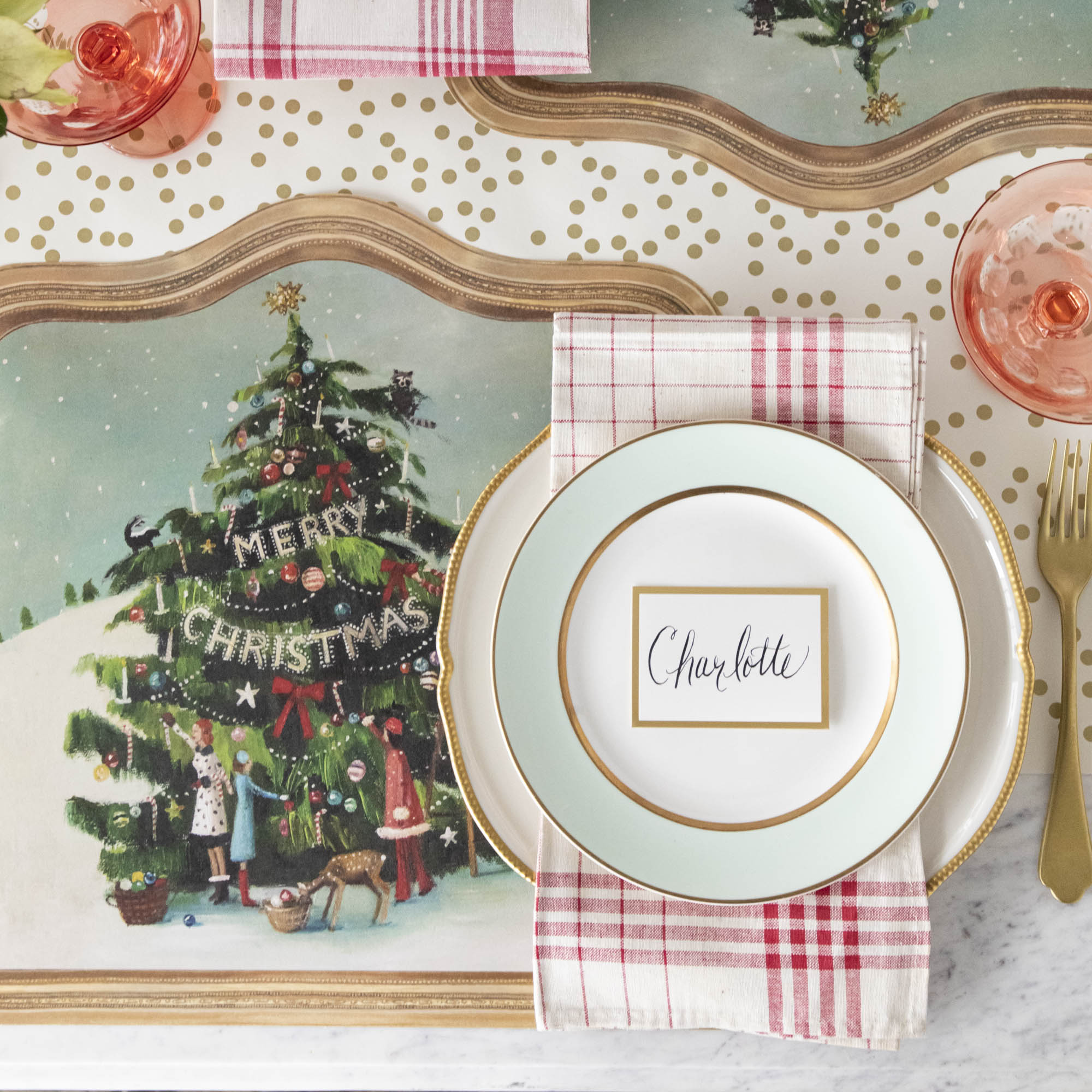 The Die-cut Trim the Tree Placemat under an elegant Christmas-themed table setting, from above.