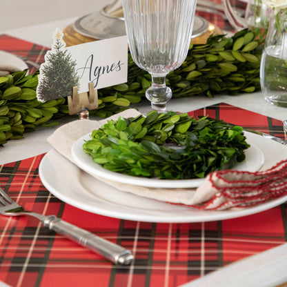 A MISPRINT Red Plaid Placemat in a red plaid fabric with black and white squares, perfect for bringing the Christmas spirit to any holiday table. (Brand: Hester &amp; Cook)