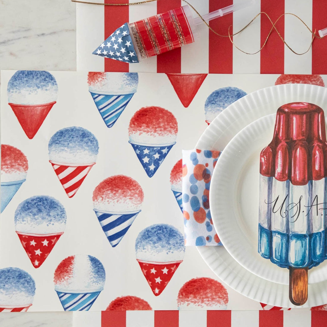 Close-up of a Snow Cone Placemat under a patriotic place setting, from above.