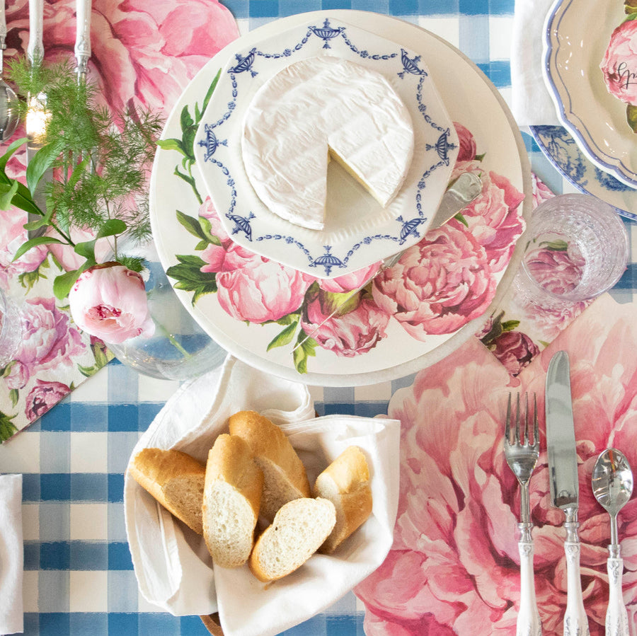 Peony Serving Paper on a cake stand under a plate of cheese, on an elegant table setting.