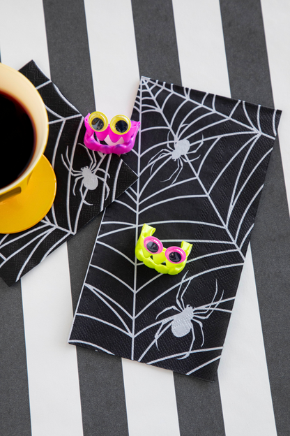 Two Spiderweb Napkins, one Guest and one Cocktail, under a cup of coffee and some Halloween treats.