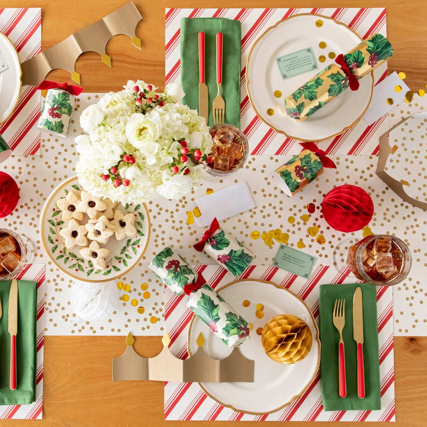 An elegant Christmas themed table setting with flowers, star shaped jelly cookies, and the Peppermint Stripe Placemat with a Gold Confetti Runner underneath.