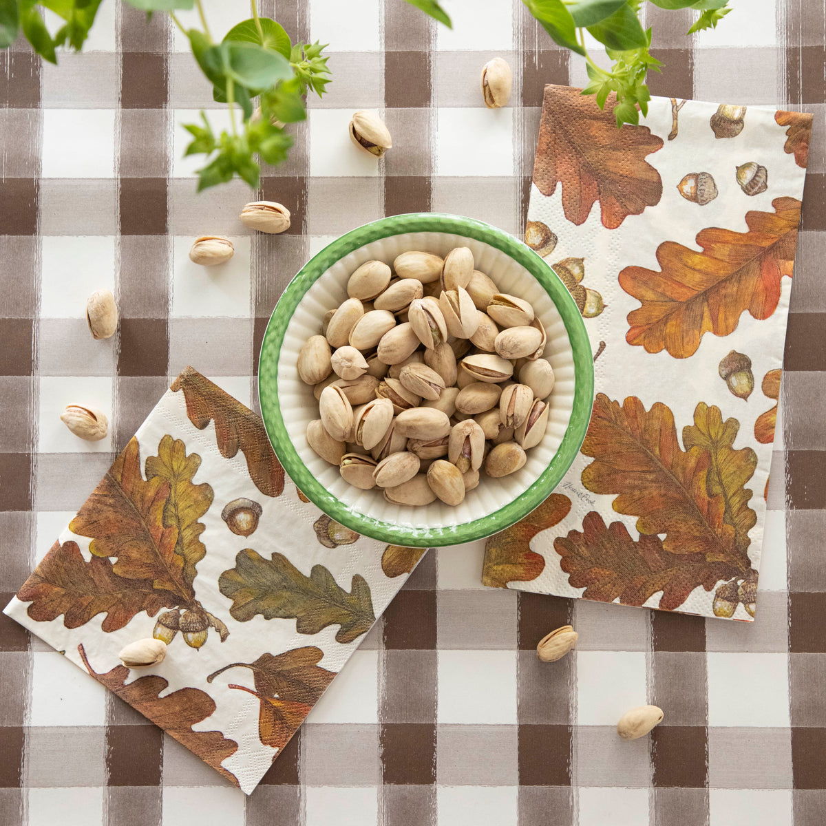 A bowl of pistachios on a table with an Autumn Leaves Cocktail Napkin and an Autumn Leaves Guest Napkin.