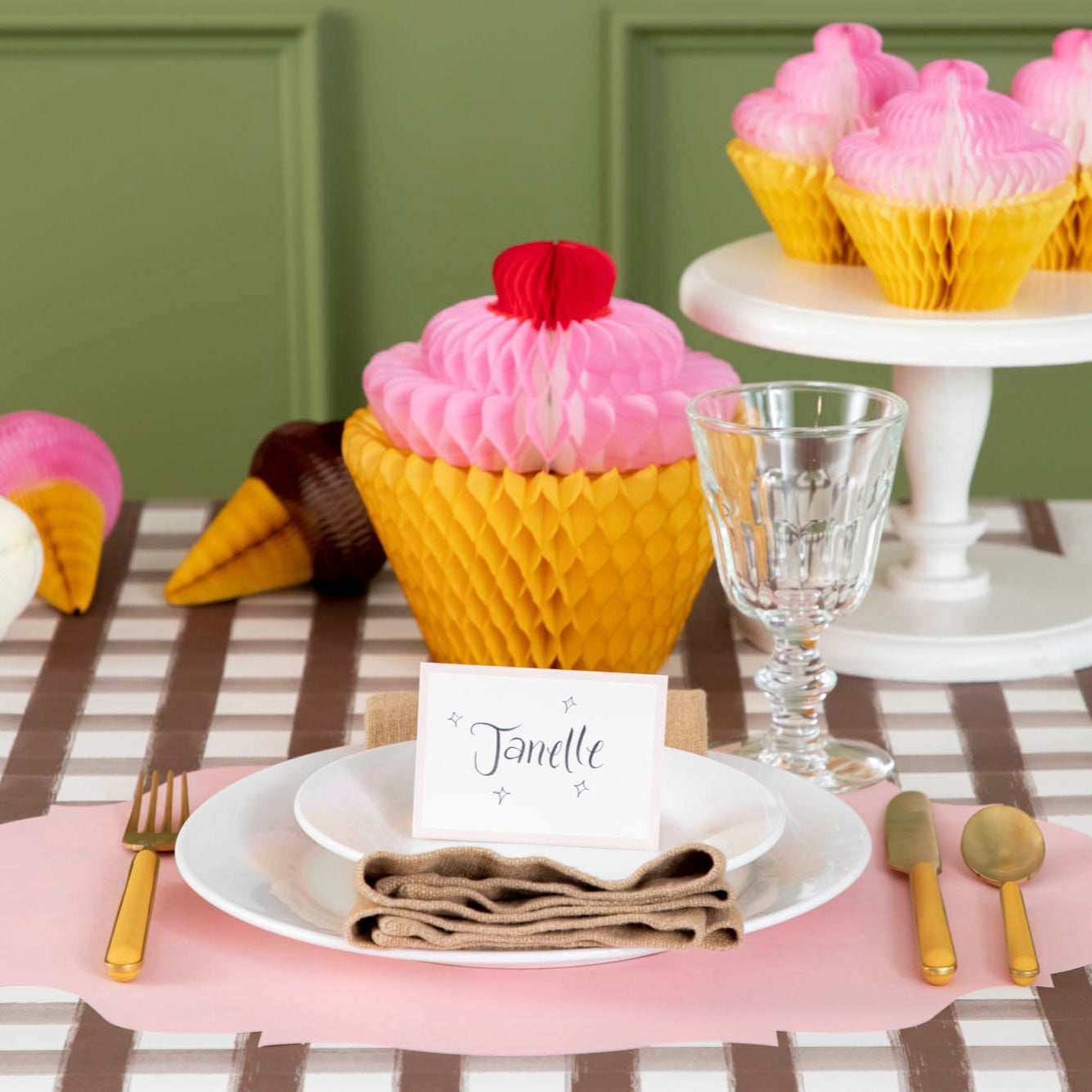 Pink Frame Place Card with &quot;Janelle&quot; written on it, centered on dinner plates, on a sweet treat themed place setting.