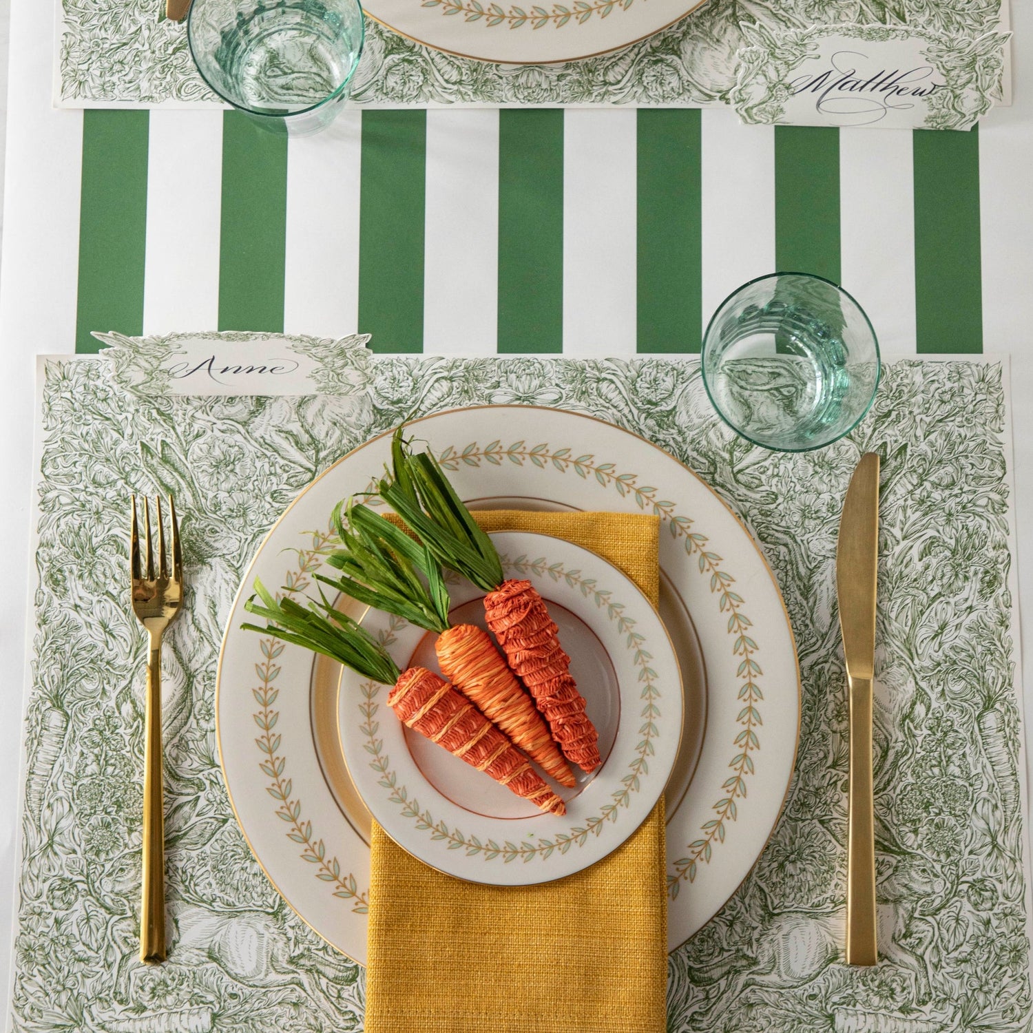 A densely-packed illustration of rabbits, flowers, carrots and foliage, in medium green over white.