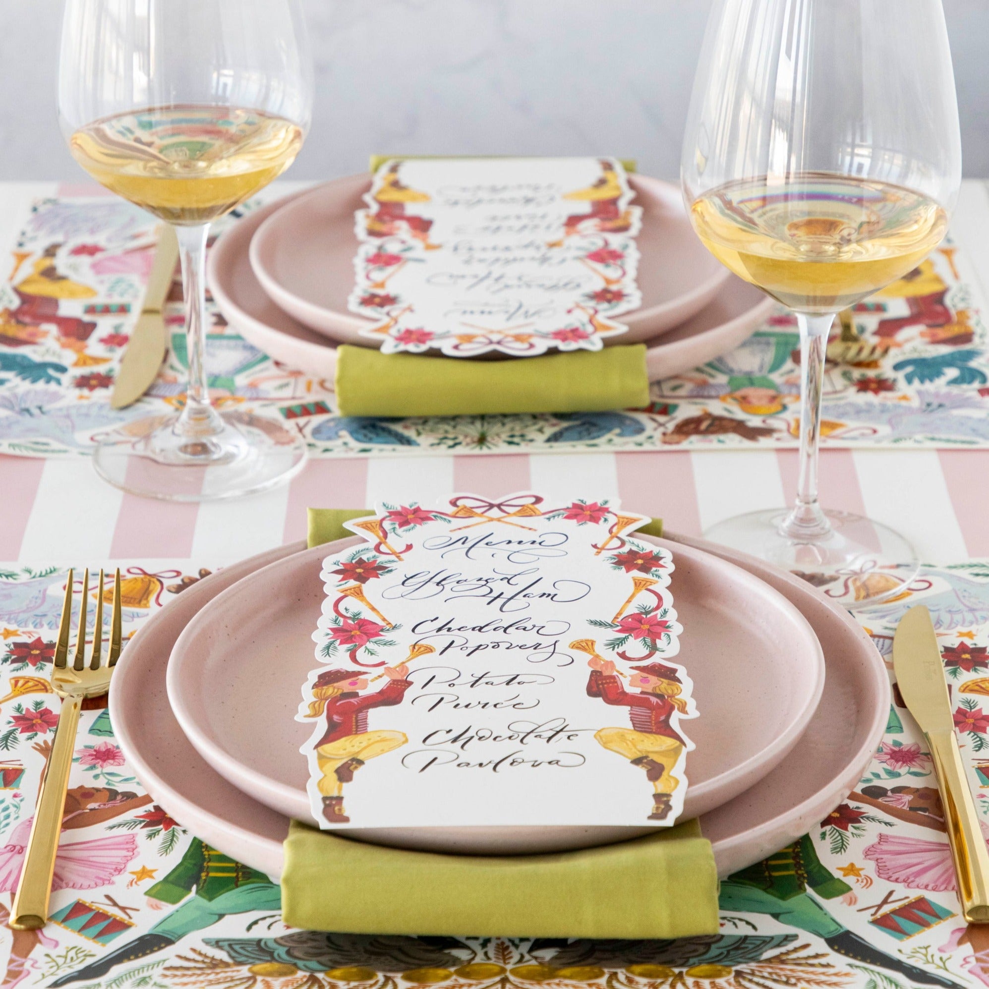 A holiday table setting featuring Pipers Piping Table Cards resting on each plate.