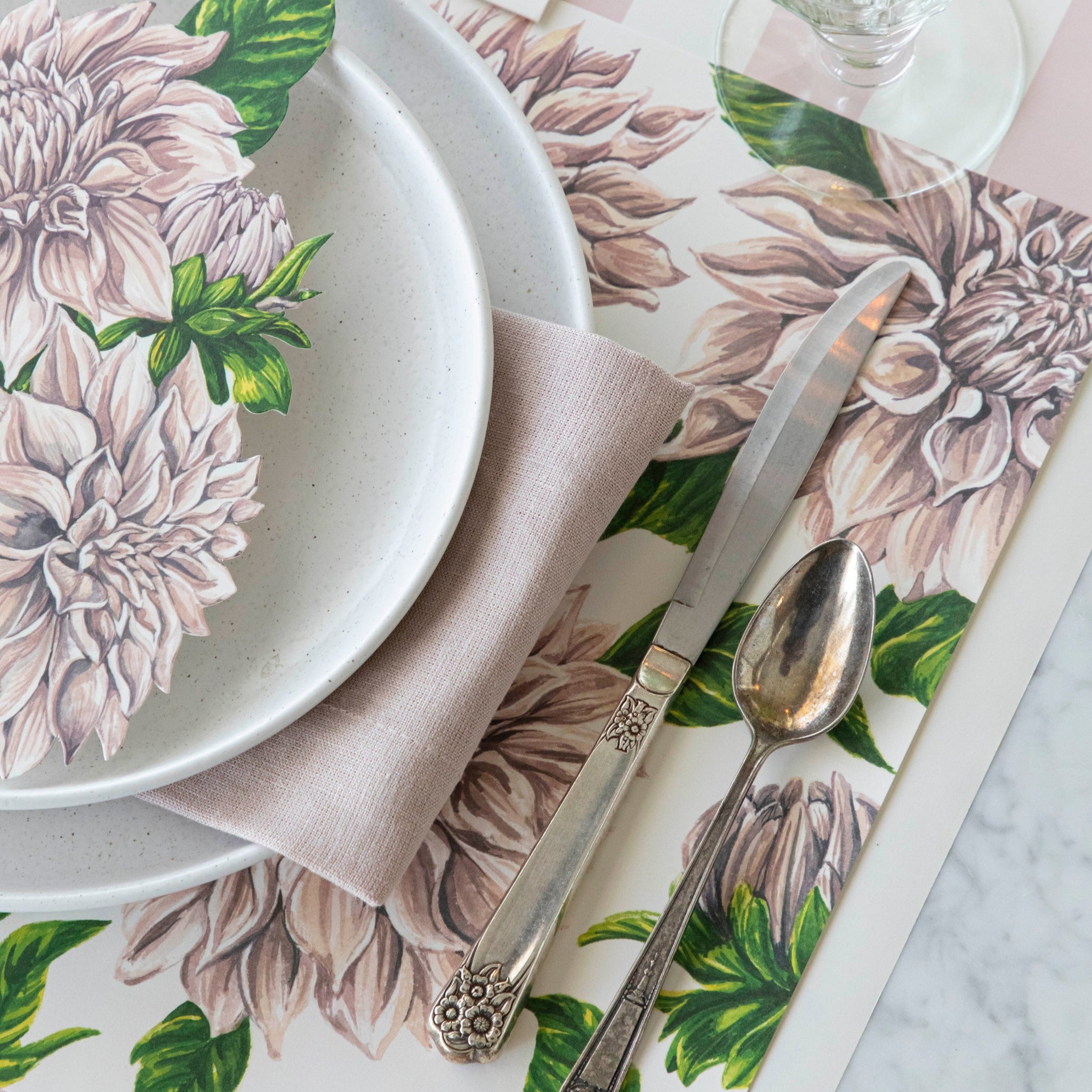 Delightful Dahlias Placemat under a place setting for one, on an elegant table.