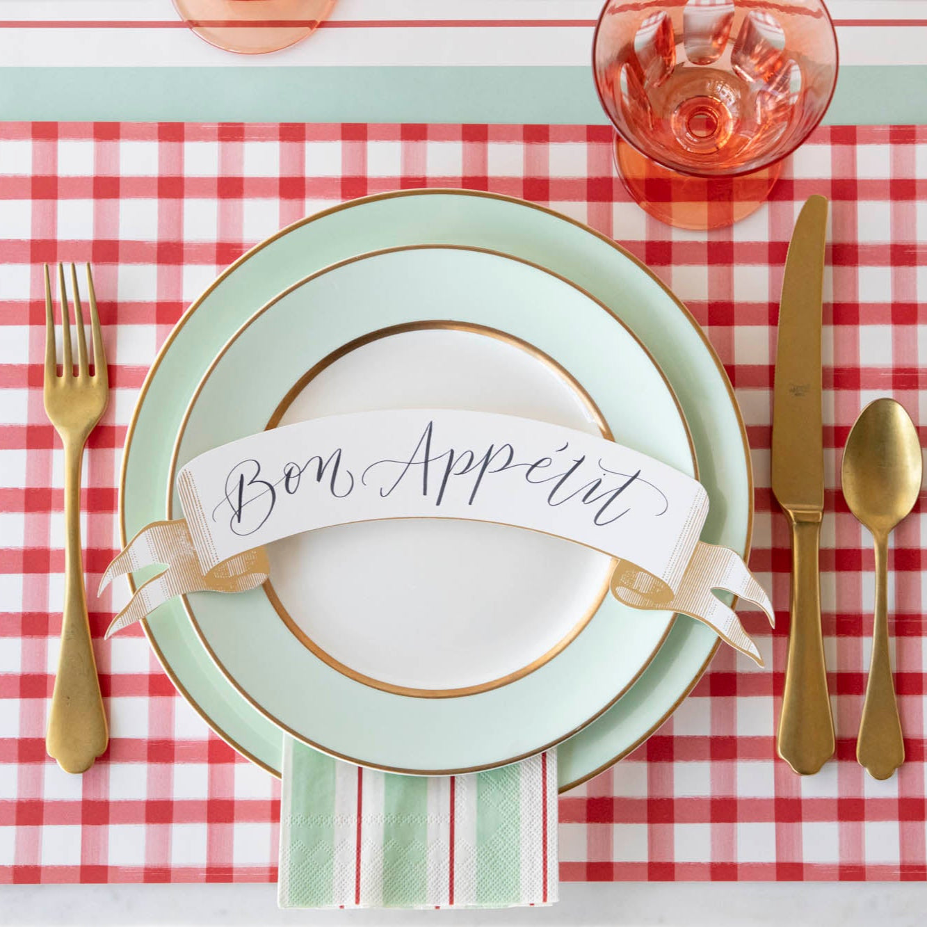 Classic Gold Banner Table Accent with &quot;Bon Appetit&quot; written on it, on the dinner plates of a place setting.