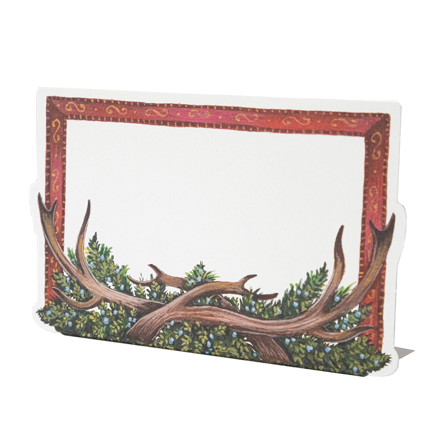 A die-cut standing place card featuring a red-framed open white rectangle with antlers and juniper springs along the bottom edge.