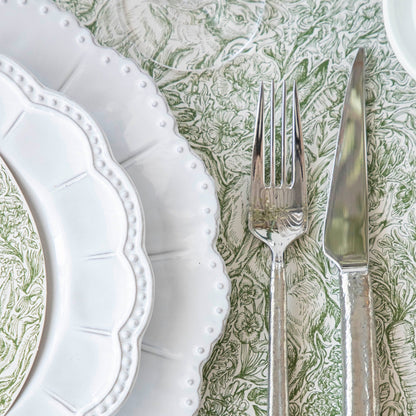 A densely-packed illustration of rabbits, flowers, carrots and foliage, in medium green over white.